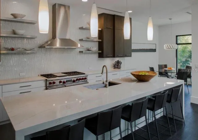 a kitchen with stainless steel appliances a sink a stove and wooden floor