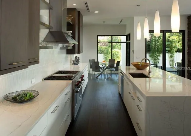 a kitchen with stainless steel appliances granite countertop a sink a stove and a refrigerator