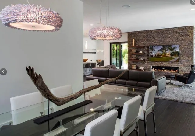 a living room with furniture a chandelier and a fireplace