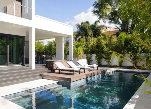 a view of a swimming pool with chairs in patio