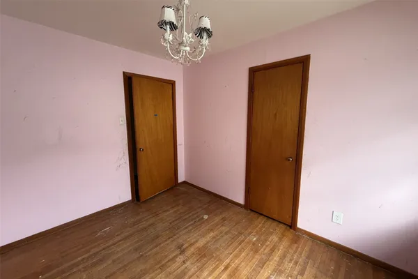 an empty room with wooden floor and a window