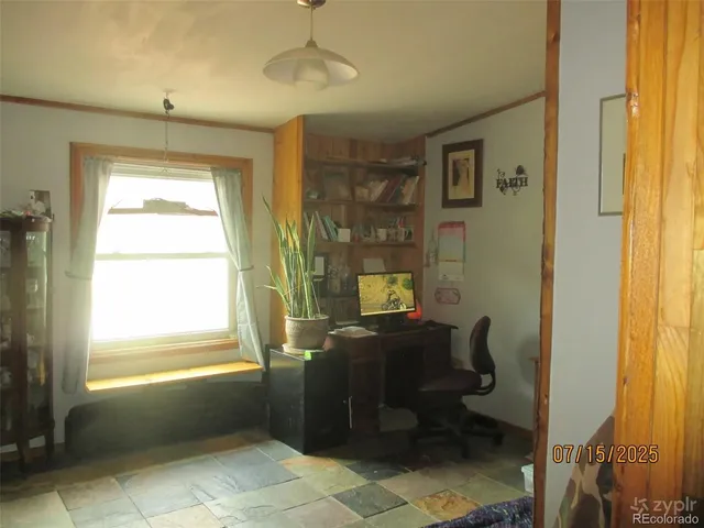 a view of a workspace with furniture and a window