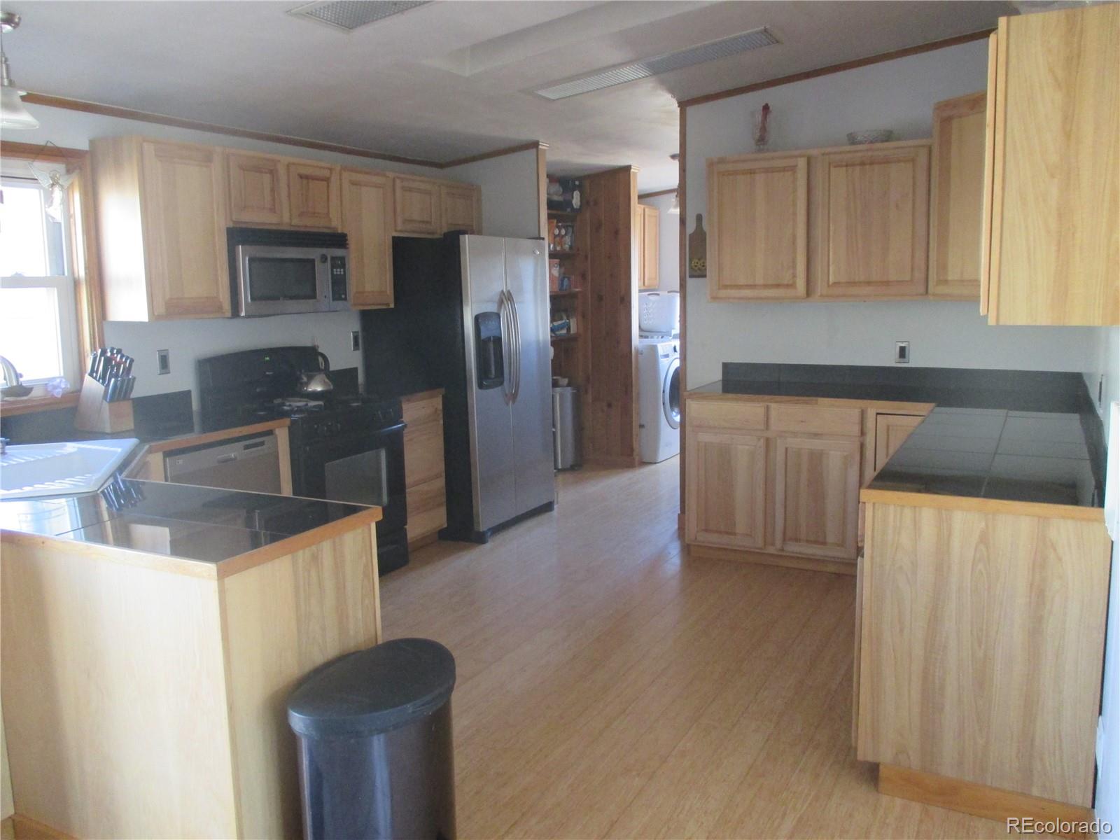 15 Sloan Road Livermore, CO 80536 - Photo 23 of 33 a kitchen with granite countertop a refrigerator and a stove top oven
