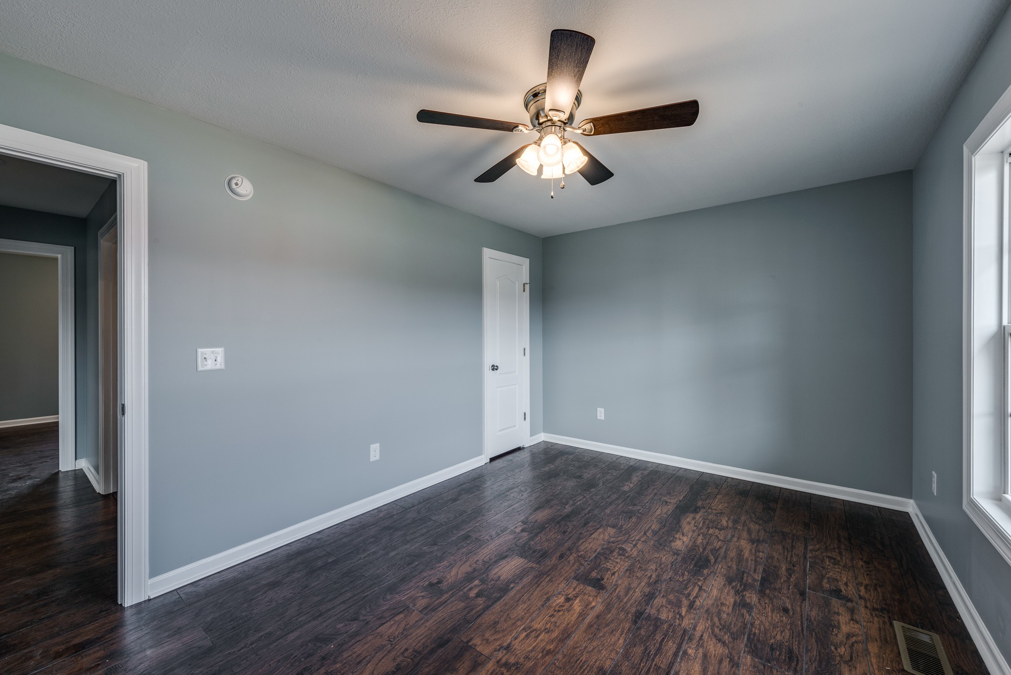 1 Holmes Gap Road Alexandria, TN 37012 - Photo 27 of 30 an empty room with wooden floor chandelier fan and windows