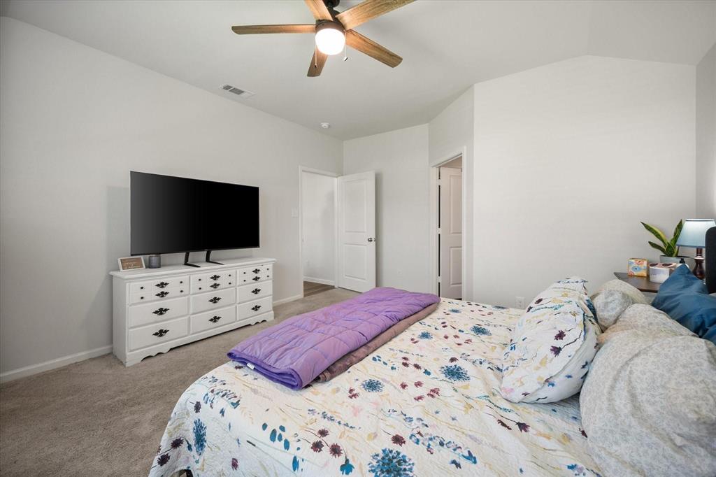 909 Avagail Avenue Springtown, TX 76082 - Photo 17 of 26 a bedroom with a bed and a flat screen tv