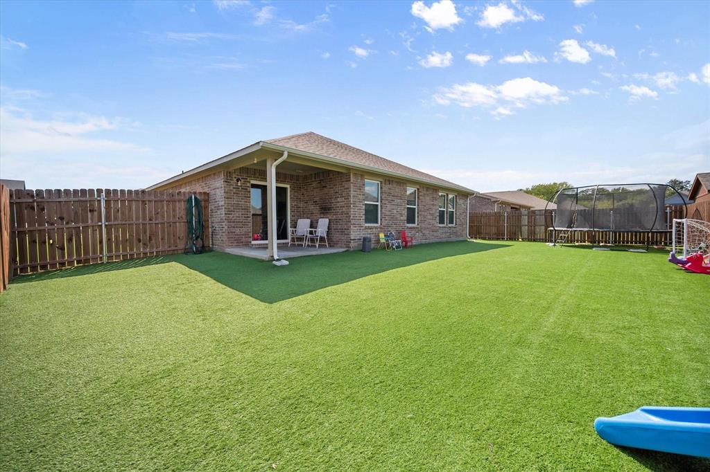 909 Avagail Avenue Springtown, TX 76082 - Photo 25 of 26 a view of a house with a yard and sitting area