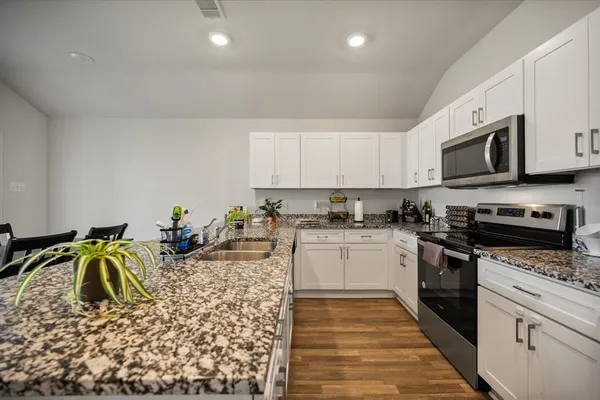 a kitchen with appliances a sink and cabinets