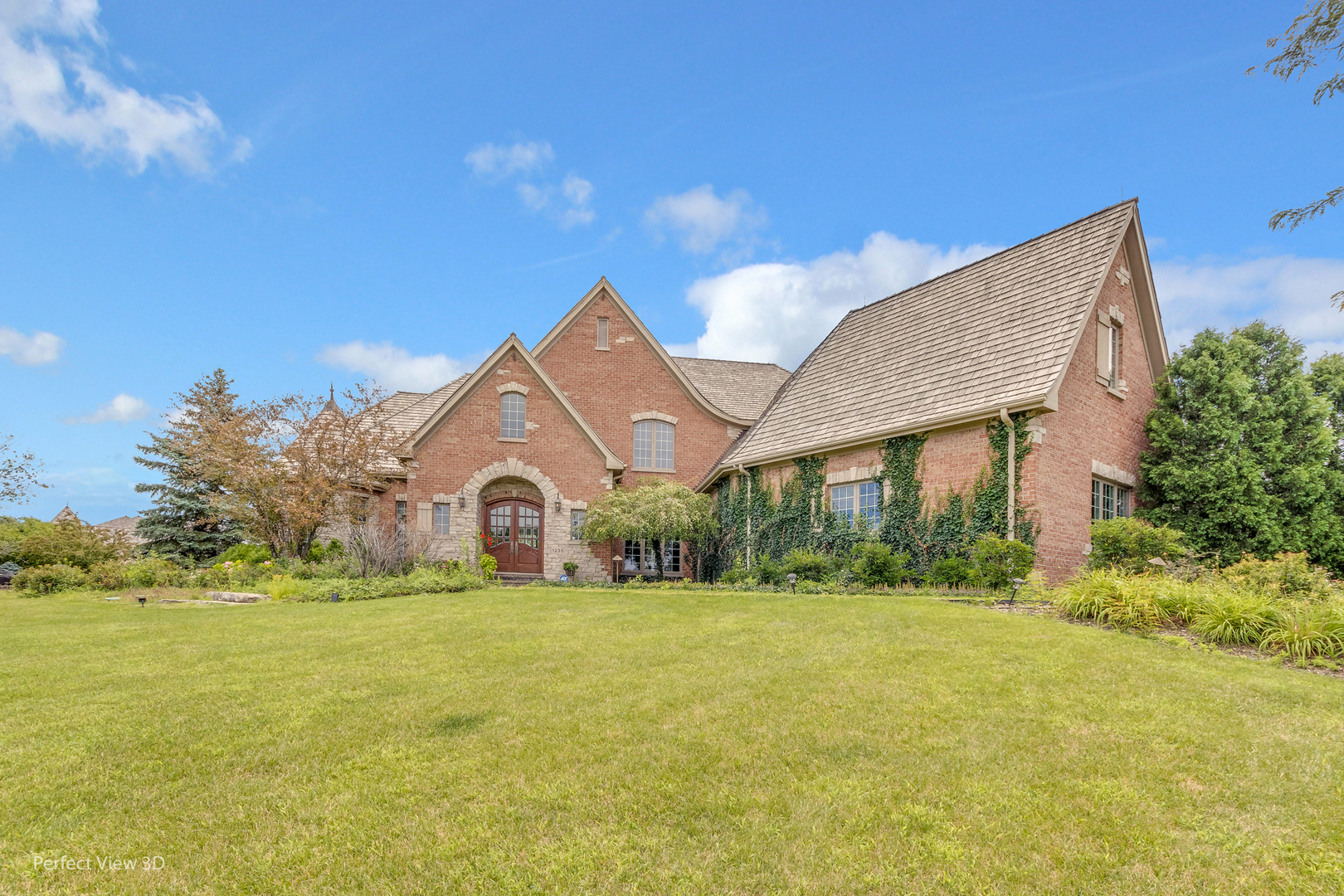 a front view of a house with yard and green space