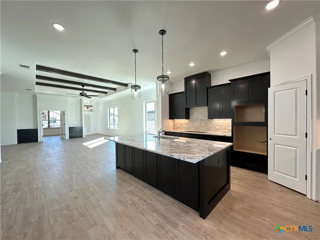a kitchen with stainless steel appliances granite countertop a counter top a refrigerator and a sink