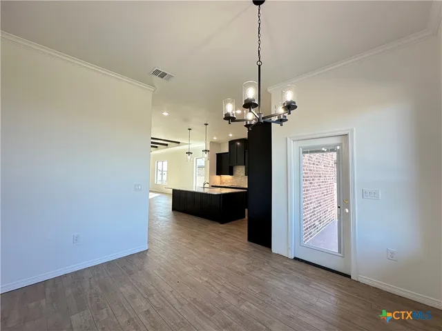 a view of a room with a stylish ceiling fan and entryway