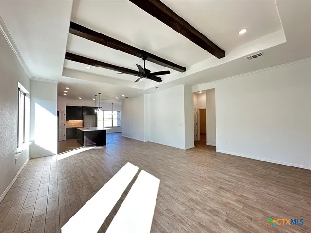 a view of empty room with wooden floor