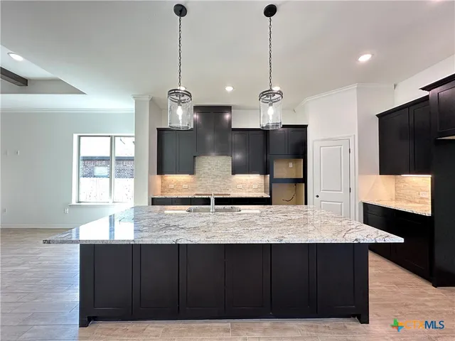 a kitchen with stainless steel appliances granite countertop wooden cabinets a refrigerator and a sink