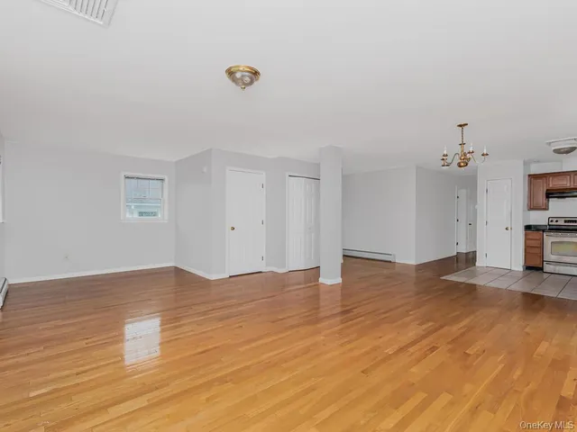 a view of empty room with wooden floor