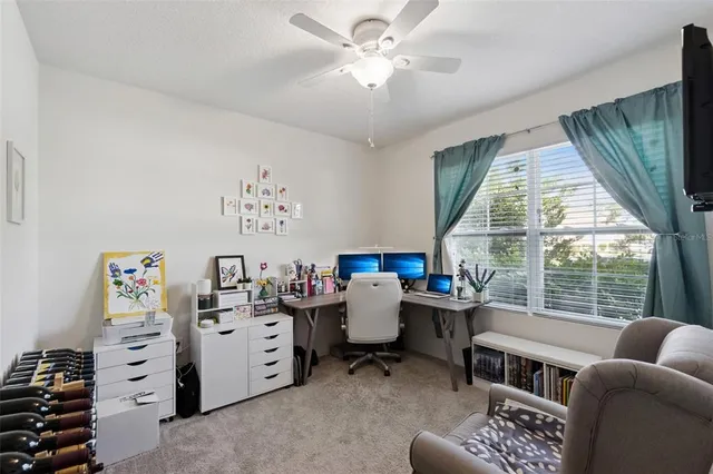 a view of a livingroom with workspace and a window