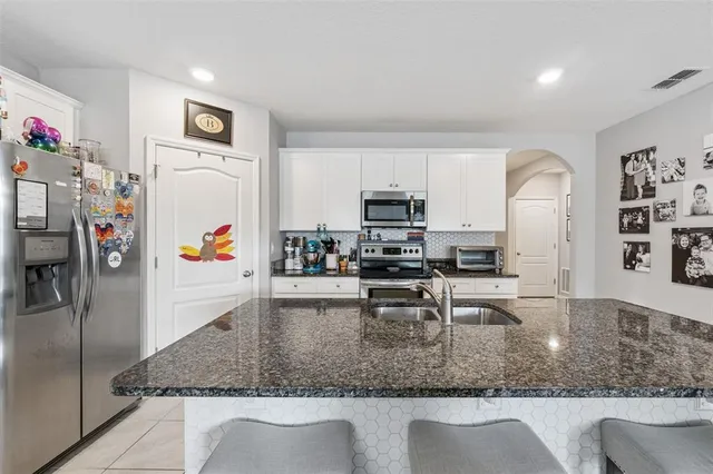 a kitchen with stainless steel appliances granite countertop a sink refrigerator and microwave