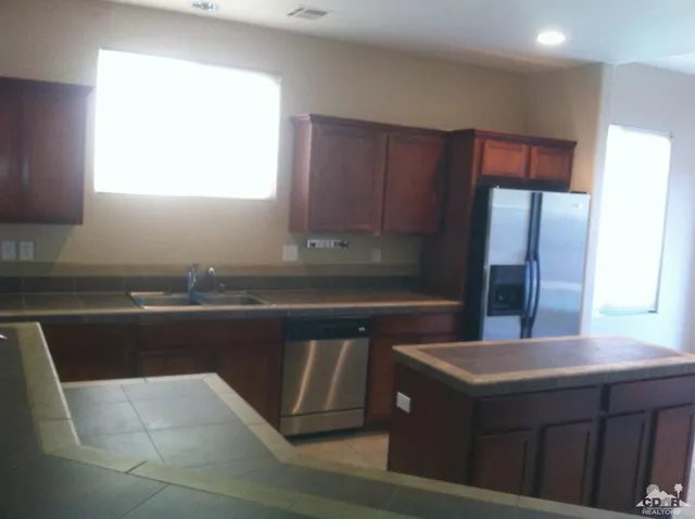 a kitchen with a sink a refrigerator and window
