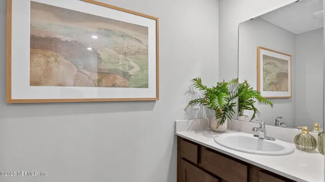 a bathroom with a granite countertop sink a mirror and vanity