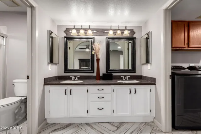 a bathroom with a granite countertop double vanity sink and a mirror