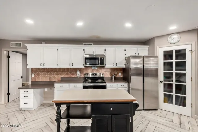 a kitchen with stainless steel appliances a stove a refrigerator sink and cabinets