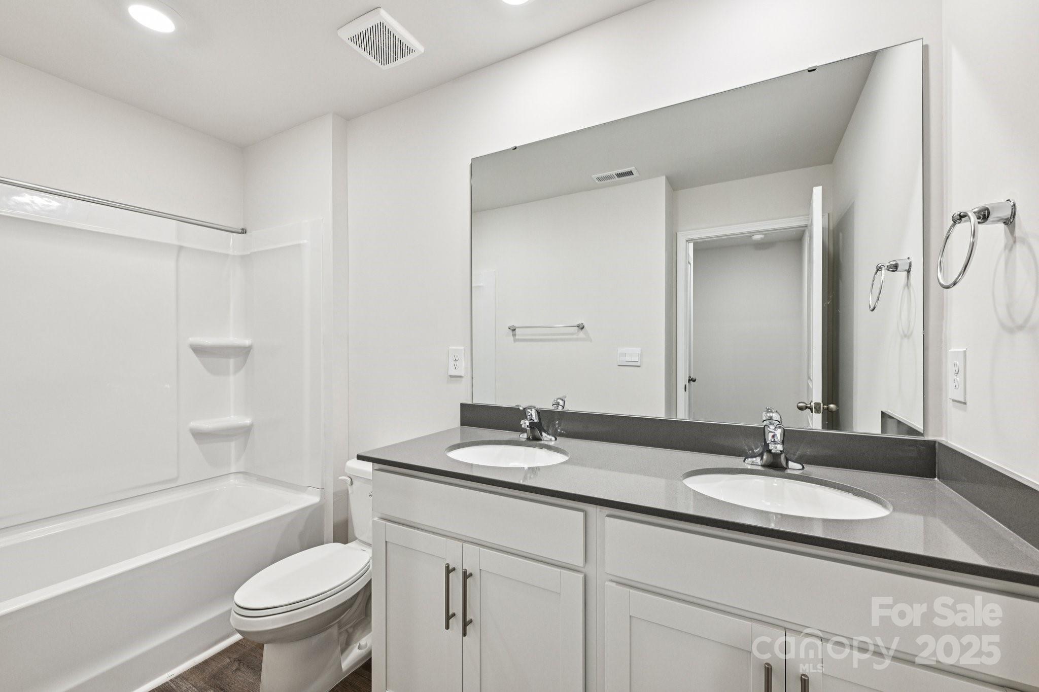 7648 Bainbridge Road Sherrills Ford, NC 28673 - Photo 23 of 25 a bathroom with a granite countertop sink toilet a mirror and shower