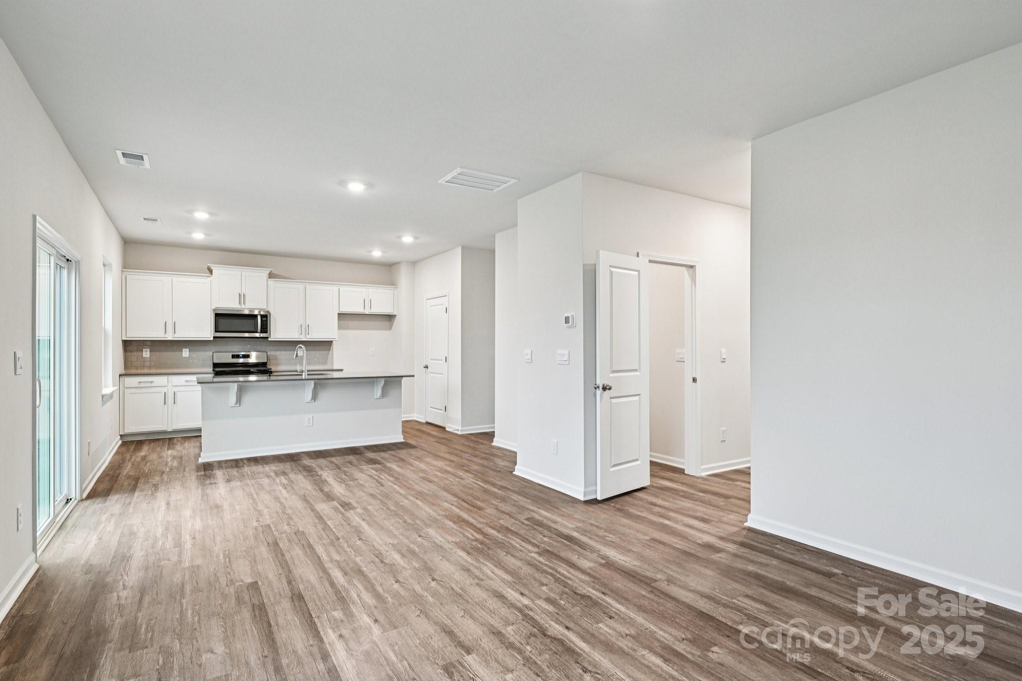 7648 Bainbridge Road Sherrills Ford, NC 28673 - Photo 4 of 25 a living room with stainless steel appliances kitchen island hardwood floor and a view of kitchen