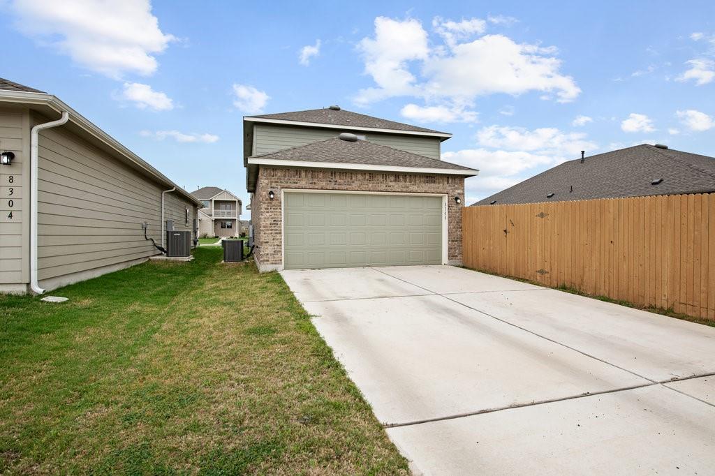 8308 Daisy Cutter Crossing Georgetown, TX 78626 - Photo 27 of 27 A well-maintained concrete driveway leads to a classic brick facade with an attached garage.