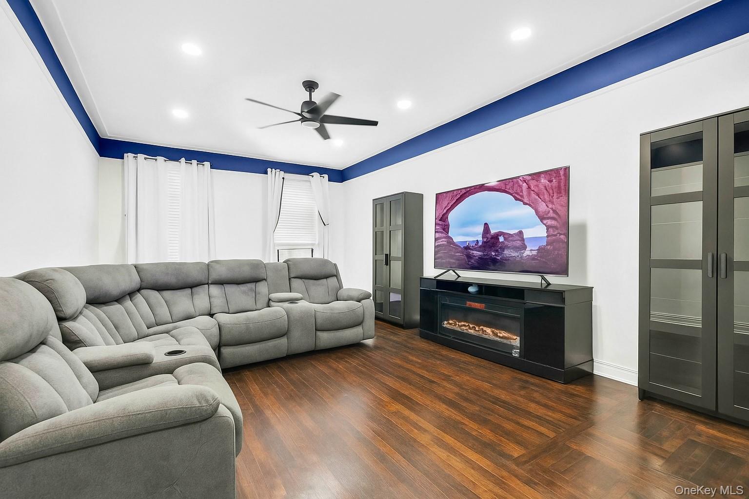 3420 83rd Street, Unit 4F Queens, NY 11372 - Photo 3 of 12 a living room with furniture a flat screen tv and a ceiling fan