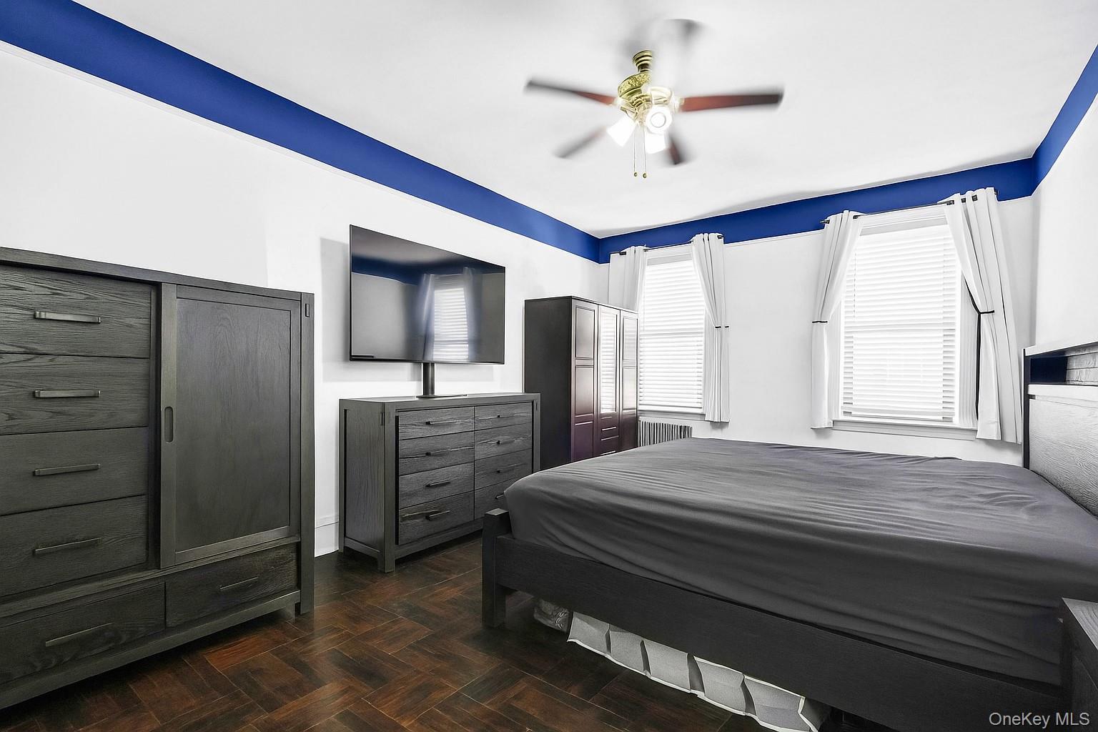 3420 83rd Street, Unit 4F Queens, NY 11372 - Photo 5 of 12 a bedroom with a bed and a chandelier