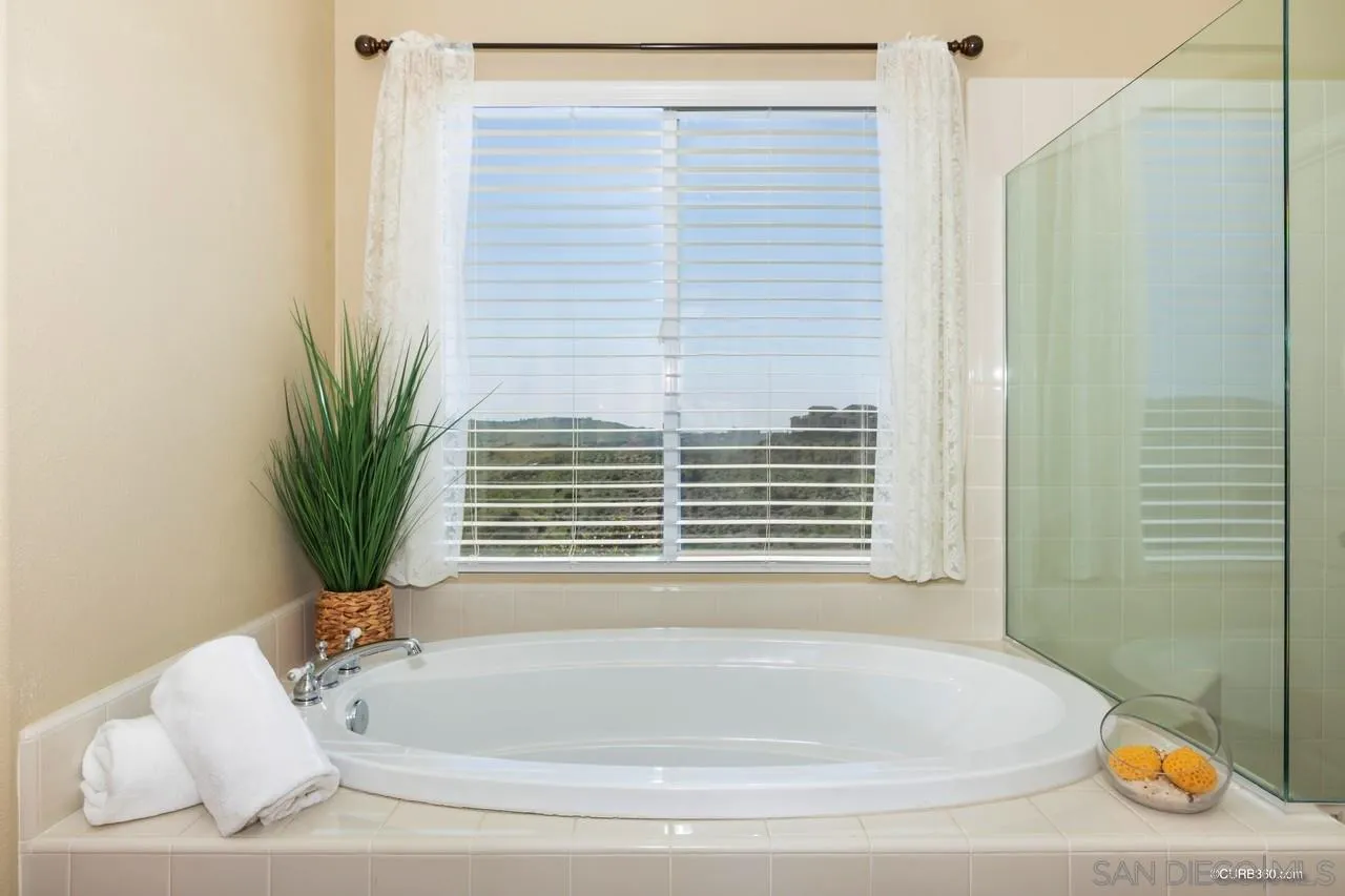 16290 Deer Ridge Road San Diego, CA 92127 - Photo 9 of 36 a bathroom with bathtub and window