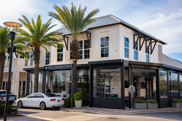 a view of a building with a street sign and palm trees