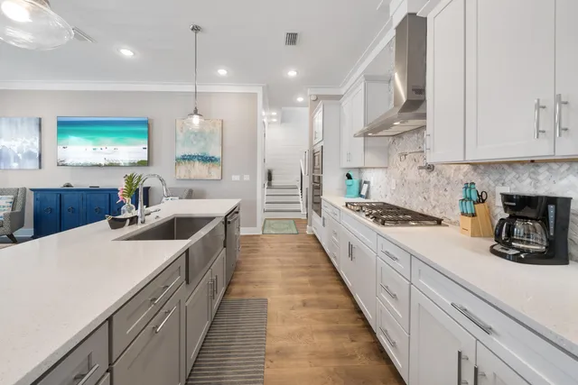a large kitchen with kitchen island a stove a sink a refrigerator and white cabinets