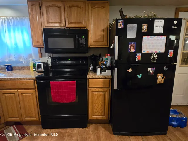 a kitchen with stainless steel appliances kitchen island granite countertop a refrigerator stove and microwave