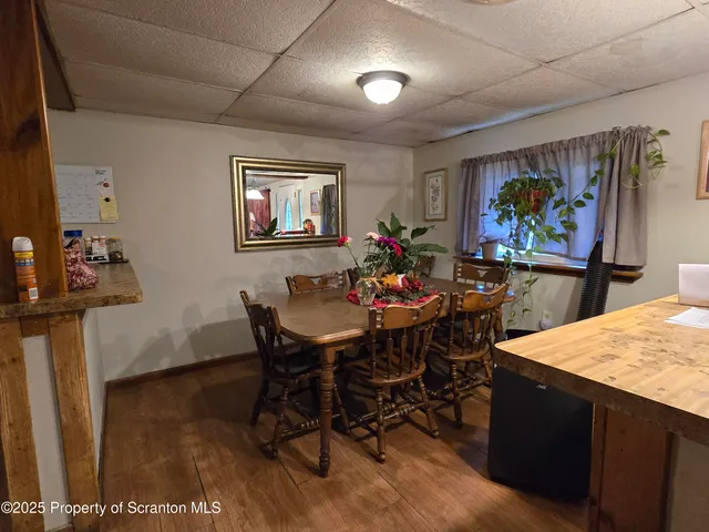 a view of a dining room with furniture a rug and wooden floor