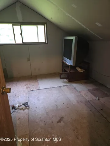 a view of a livingroom with an empty space and a window