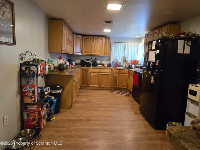 a kitchen with refrigerator and cabinets