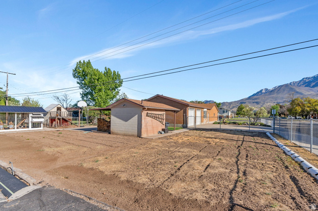 377 North 650 East, Unit 9 Orem, UT 84097 - Photo 3 of 9 Expansive land parcel featuring prepared garden beds, a detached storage building, and an animal enclosure