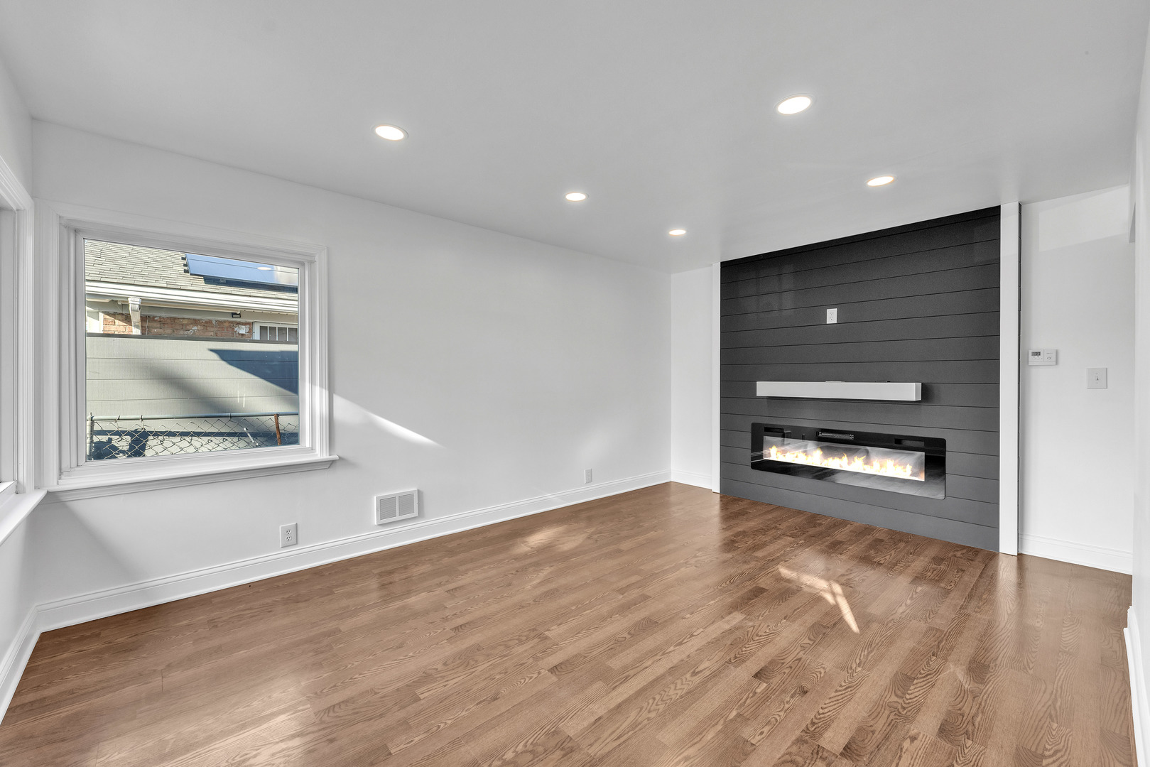 7817 South Kenton Avenue Chicago, IL 60652 - Photo 4 of 29 a view of an empty room with a window and wooden floor