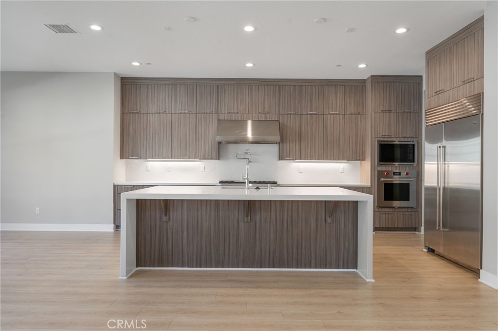 20637 West Hummingbird Porter Ranch Porter Ranch, CA 91326 - Photo 11 of 53 a kitchen with kitchen island granite countertop a sink and a refrigerator