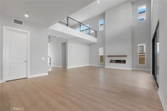 a view of empty room with wooden floor and fireplace