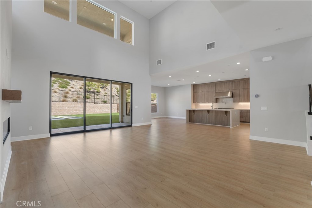 20637 West Hummingbird Porter Ranch Porter Ranch, CA 91326 - Photo 9 of 53 a view of empty room with wooden floor and a floor to ceiling window