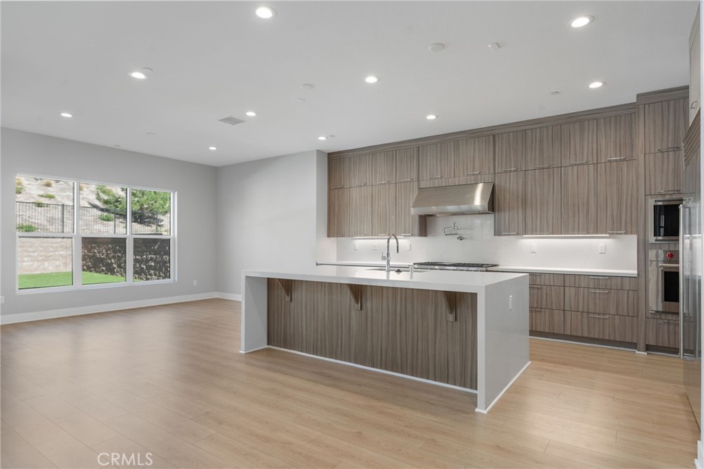 20637 West Hummingbird Porter Ranch Porter Ranch, CA 91326 - Photo 10 of 53 a large kitchen with kitchen island a sink stainless steel appliances and cabinets