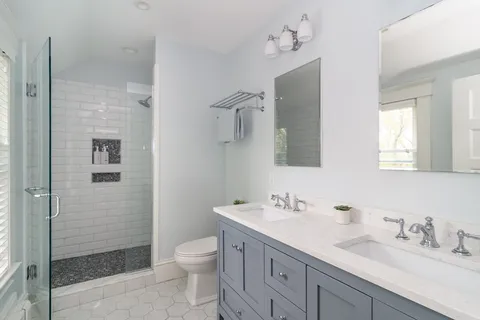 a bathroom with a granite countertop sink a toilet and shower
