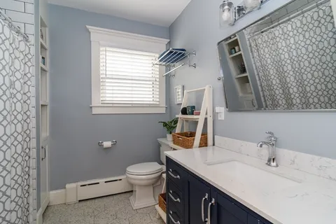 a bathroom with a toilet sink and mirror