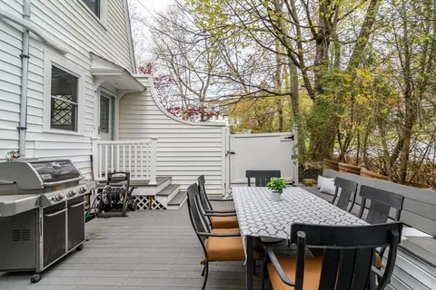 a view of a patio with table and chairs with wooden floor and fence