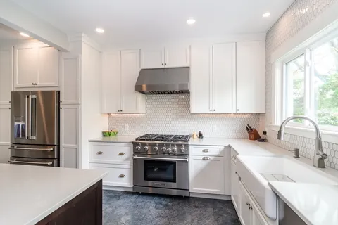 a kitchen with granite countertop a refrigerator stove and sink