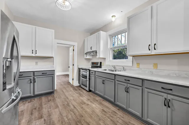 a kitchen with granite countertop white cabinets and white appliances