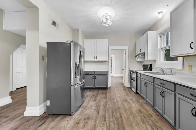 a kitchen with stainless steel appliances a refrigerator sink and cabinets