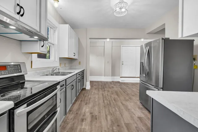 a kitchen with granite countertop a sink stove and refrigerator
