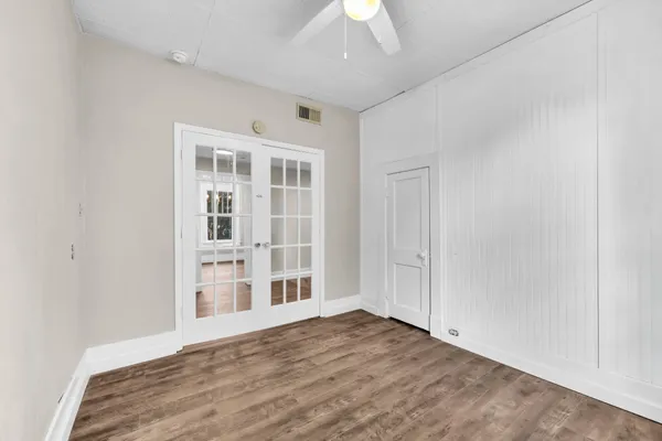 an empty room with wooden floor and windows