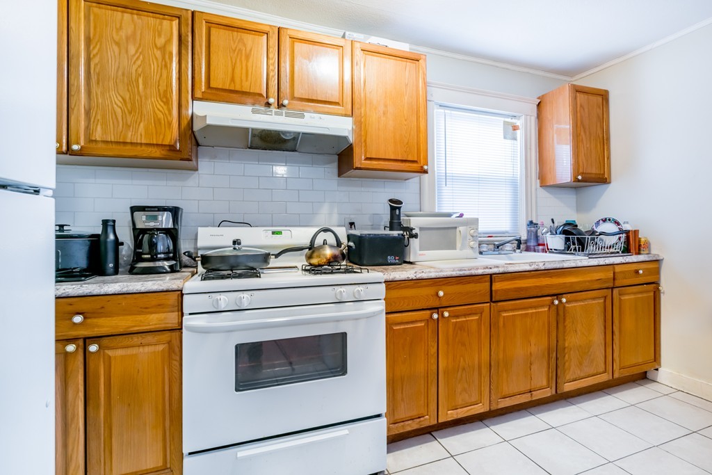 391 Concord Street Framingham, MA 01702 - Photo 12 of 27 a kitchen with stainless steel appliances granite countertop white cabinets sink and a granite counter top